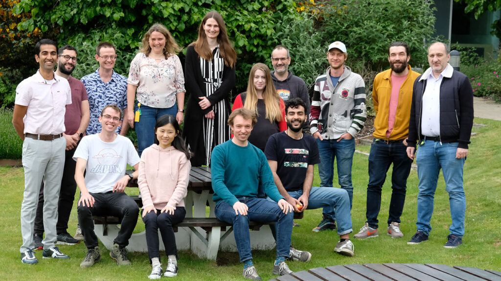 Photo of the AIM team – Front row (left to right): Doug Kelly, Jiaqi Chu, James Clegg, Babak Rahmani. Back row: Hitesh Ballani, George Mourgias-Alexandris, Daniel Cletheroe, Francesca Parmigiani, Lucinda Pickup, Grace Brennan, Ant Rowstron, Kirill Kalinin, Jonathan Westcott, Christos Gkantsidis. (Greg O'Shea and Jannes Gladrow do not appear in this photo.)